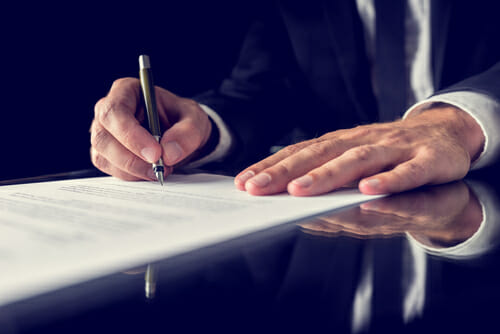 A lawyer signing a power of attorney document.